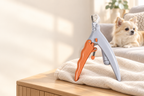 Grey and orange pet nail clipper on a towel in a calm home setting